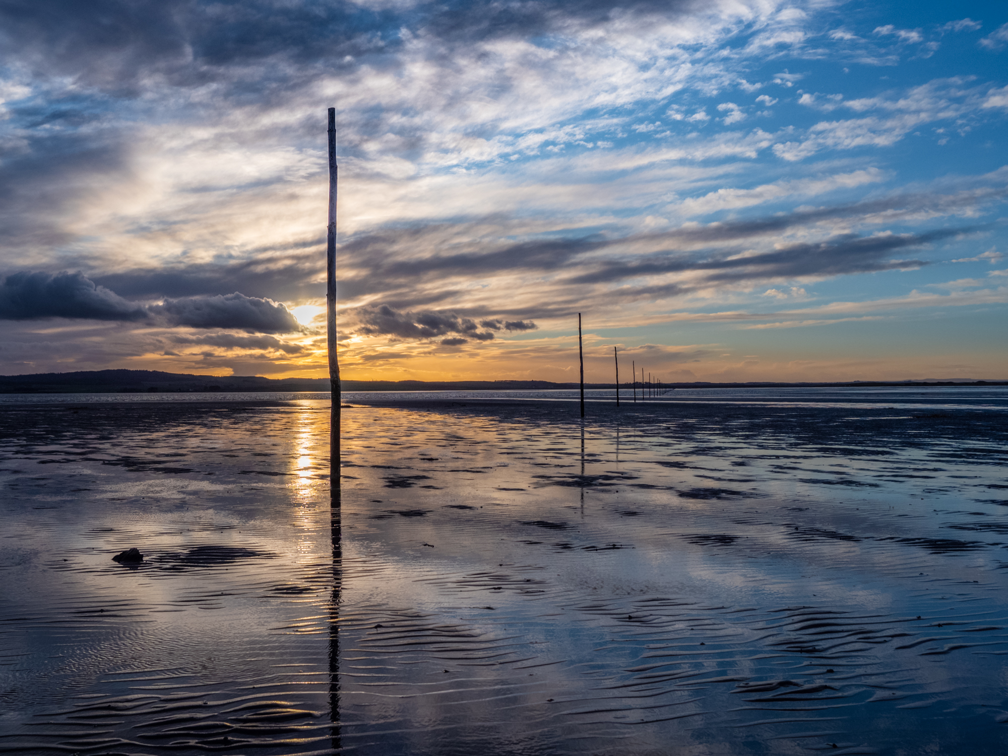 Pilgrims' Way across the salt marsh and mudflats to the Holy Island of Lindisfarne. Photographed at dusk