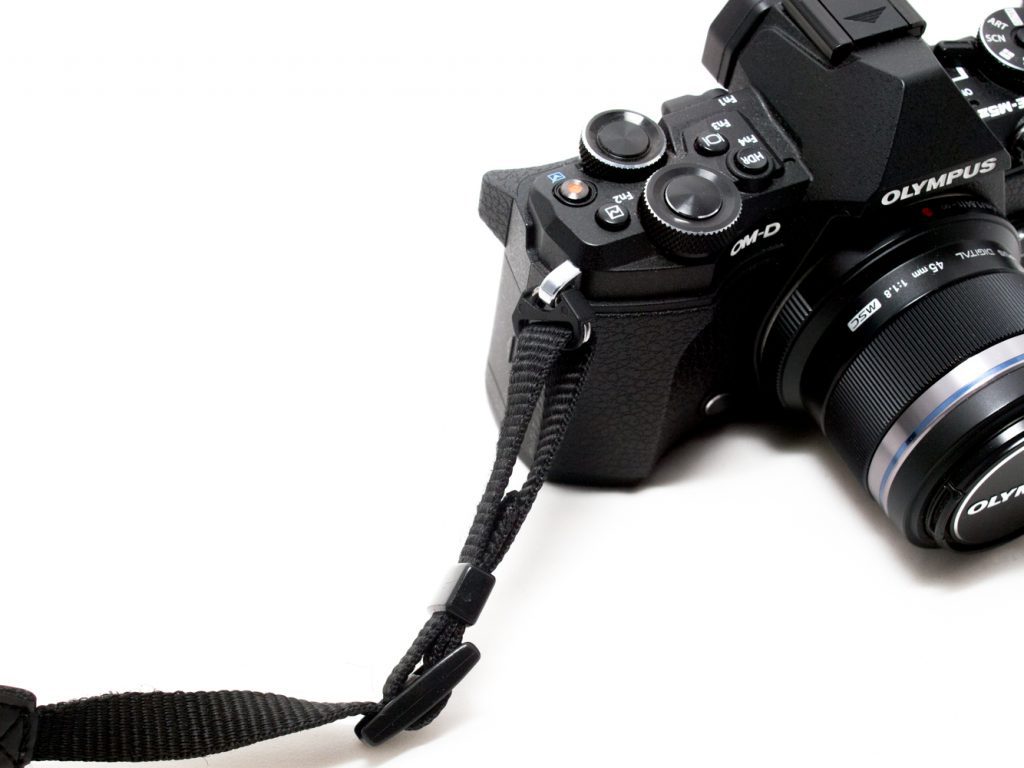 The camera strap properly secured to the camera