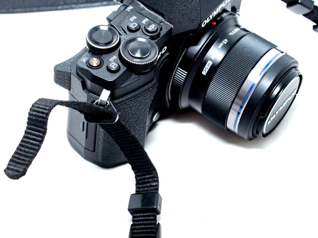 Threading the tail end through the camera's anchor point.