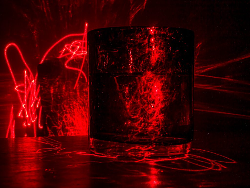 Glass of water illuminated by laser