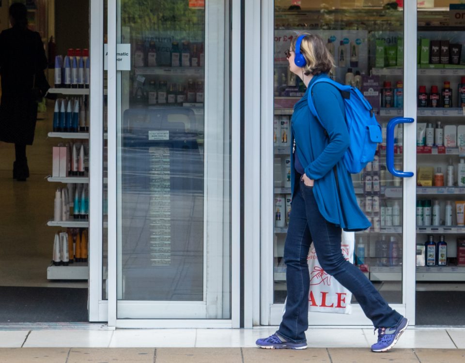 Consumerism - woman walking past a shop