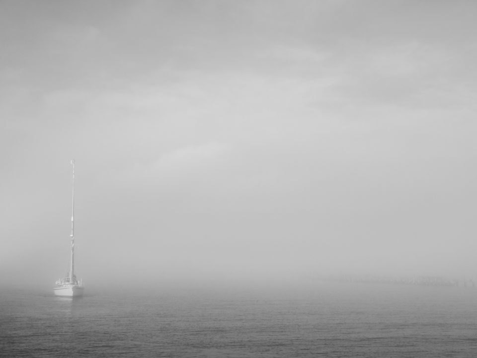 Yacht appearing out of the morning fog
