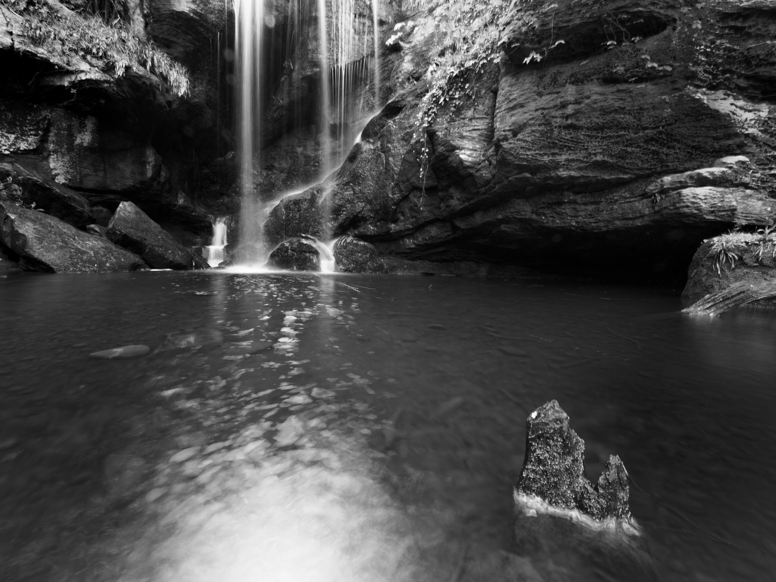 A black and white photograph of a waterfall