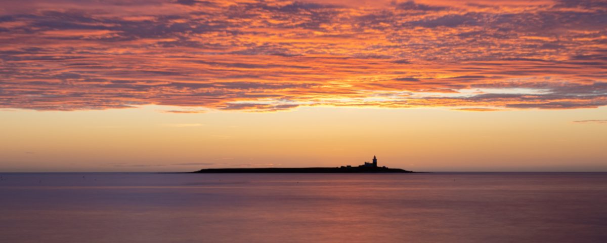 An artisan photographer will explore settings and compositions such as this pre-dawn image of Coquet Island. The clouds in the sky are lit by the sun that is not yet above the horizon.