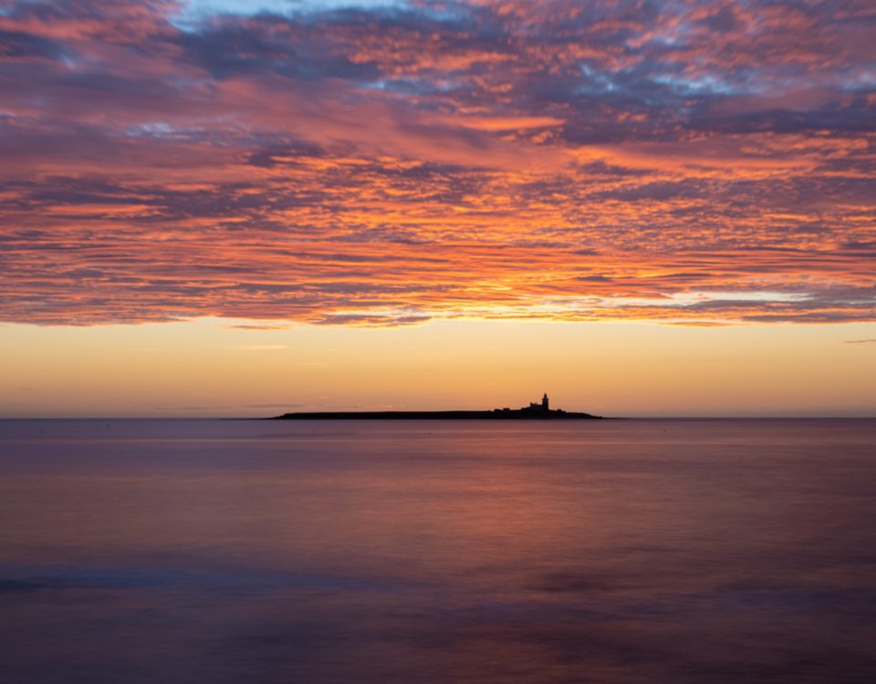 An artisan photographer will explore settings and compositions such as this pre-dawn image of Coquet Island. The clouds in the sky are lit by the sun that is not yet above the horizon.