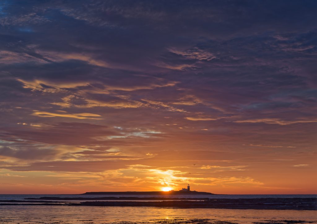 A beautiful sunrise over the sea with Coquet Island on the horizon. 
