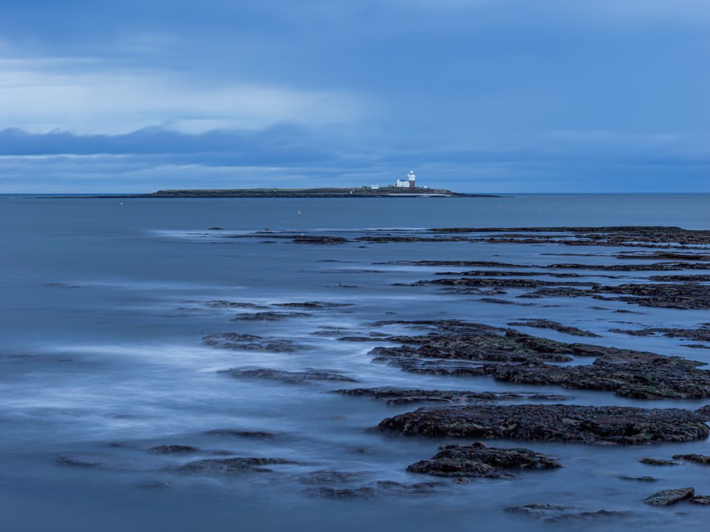 A log exposure photo of Coquet Island during the blue hour. 