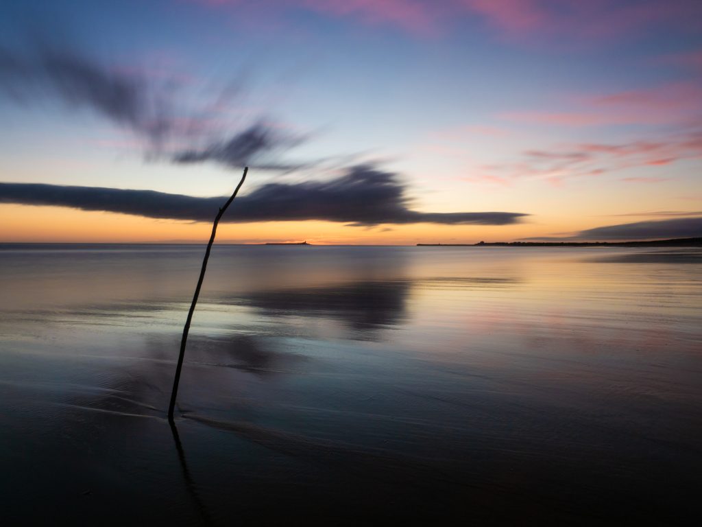 A 60-second exposure of a beach at dawn that combined LiveND with a glass ND1000 filter on the lens. Shot Using an OM System Camera (OM-1 Mark II)